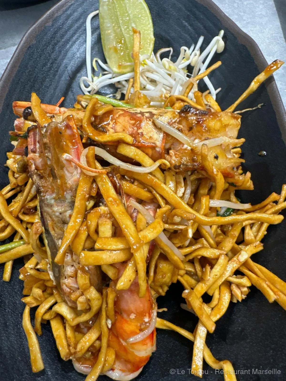 Pad Thaï aux crevettes préparé au wok au restaurant Le Toigou